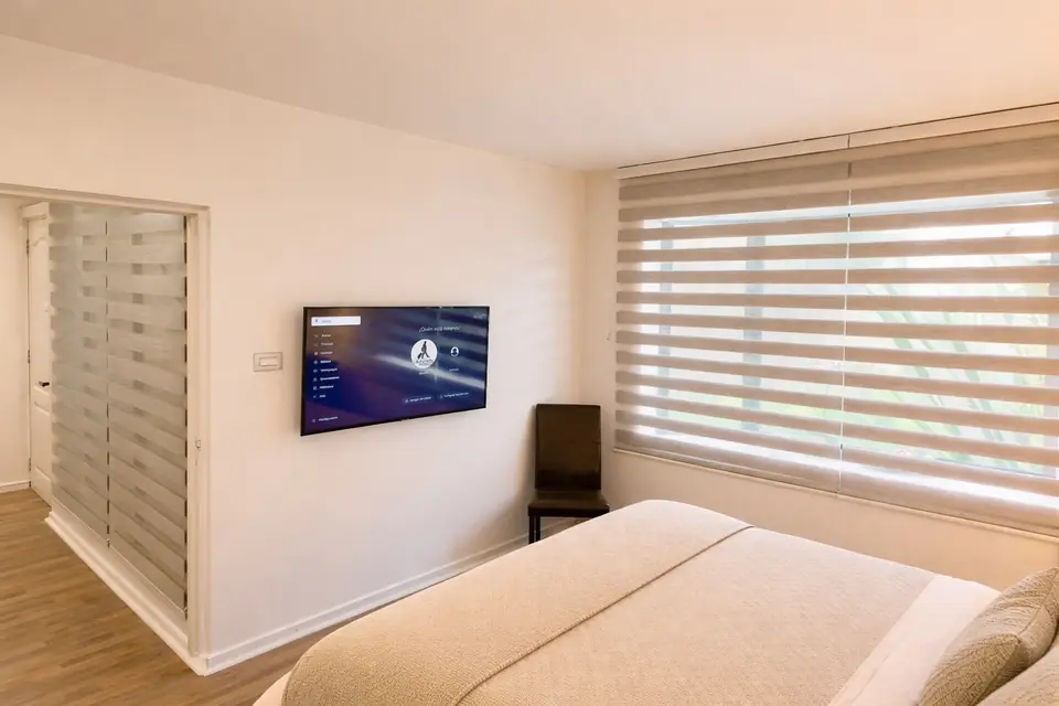 Dormitorio con cama de dos plazas y Smart TV en departamento amoblado en Chillán