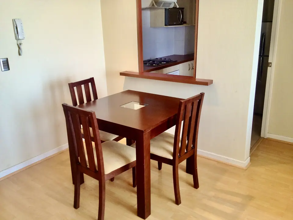 Small dining area with seating for three in a furnished apartment in Rancagua