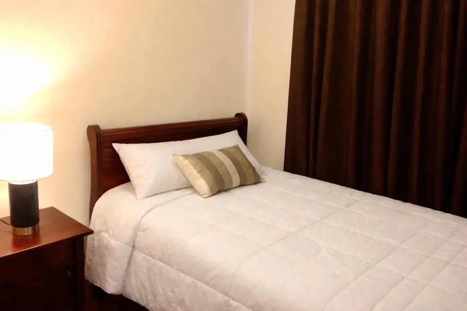 Dormitorio con cama de una y media plazas en departamento amoblado en Rancagua