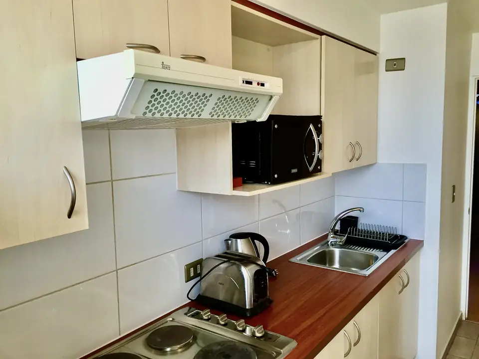 Cocina equipada de concepto cerrado en departamento amoblado Rancagua